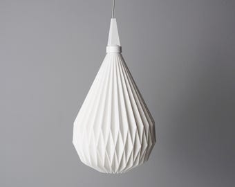 May include: A white, geometric pendant light fixture with a teardrop shape. The light has a pleated design and hangs from a white cord. The fixture is suspended against a gray background.