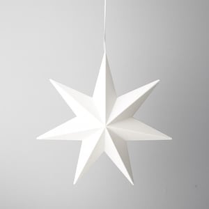 Può includere: Decorazione a forma di stella bianca a otto punte, sospesa da un sottile cordino bianco. La stella presenta punte affilate e un design minimalista, ideale per le decorazioni festive.