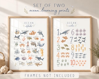 May include: A set of two educational wall art prints featuring ocean themes. One print displays an alphabet with marine life illustrations from A to Z, while the other shows numbers one through ten with corresponding counts of sea creatures.