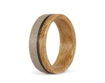 May include: A wooden ring with a band of light gray concrete and a thin black line separating the two materials.