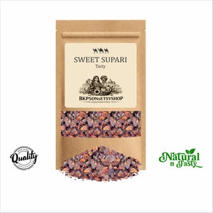 May include: A brown paper bag labeled "SWEET SUPARI Tasty" with a window showing the product. The bag has a cream-colored label with a camel illustration and the text "BKPSONSETSYSHOP RAJASTHAN INDIA". A pile of the product is at the bottom.