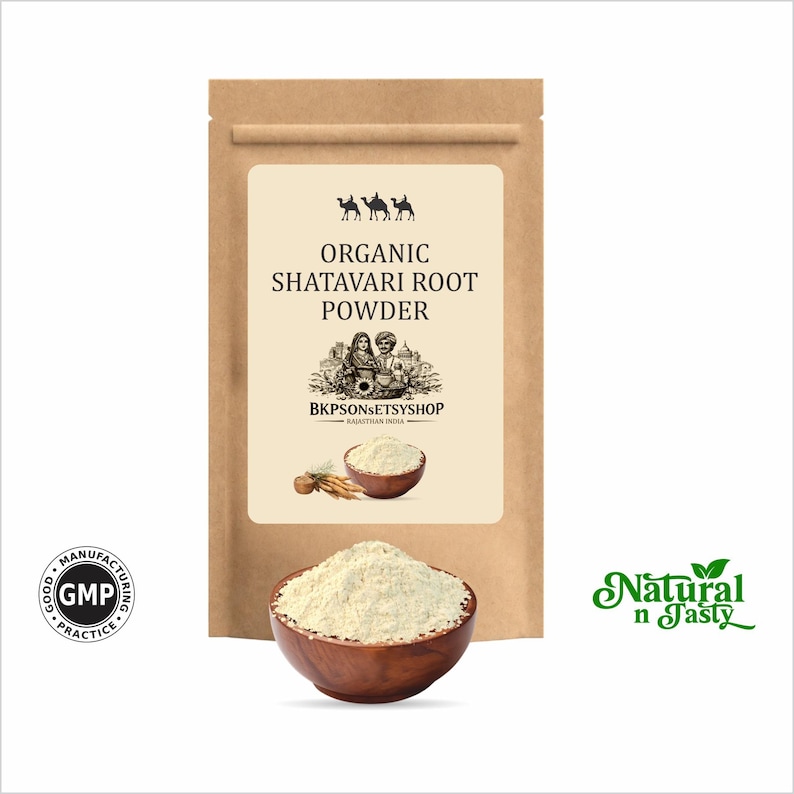 Puede incluir: Una bolsa de papel marr&oacute;n con la etiqueta "Organic Shatavari Root Powder". Un cuenco de madera lleno de polvo de color claro, con un cuenco m&aacute;s peque&ntilde;o y ra&iacute;ces tambi&eacute;n visibles. Las palabras "Natural n Tasty" est&aacute;n en verde.