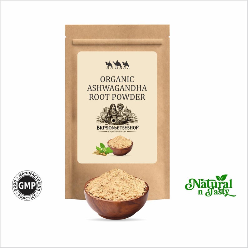 May include: A kraft paper bag with a label that reads "Organic Ashwagandha Root Powder." A wooden bowl filled with light brown powder sits in front of the bag. The words "Natural n Tasty" are in green script on the right.