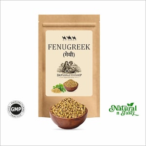Pode incluir: Uma bolsa de papel castanho rotulada FENUGREEK com um ícone de camelo, um desenho de duas pessoas e o texto BKPSONSETSYSHOP RAJASTHAN INDIA. Uma taça de madeira cheia de sementes de feno-grego castanhas está à frente, com um logótipo GMP e Natural n Tasty.