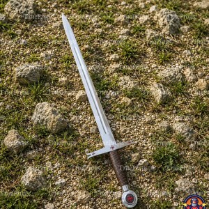 May include: A double-edged steel sword featuring a central fuller, a crossguard with red cross emblems on each side, a brown leather-wrapped grip, and a circular pommel with a red cross emblem centered on a silver background.