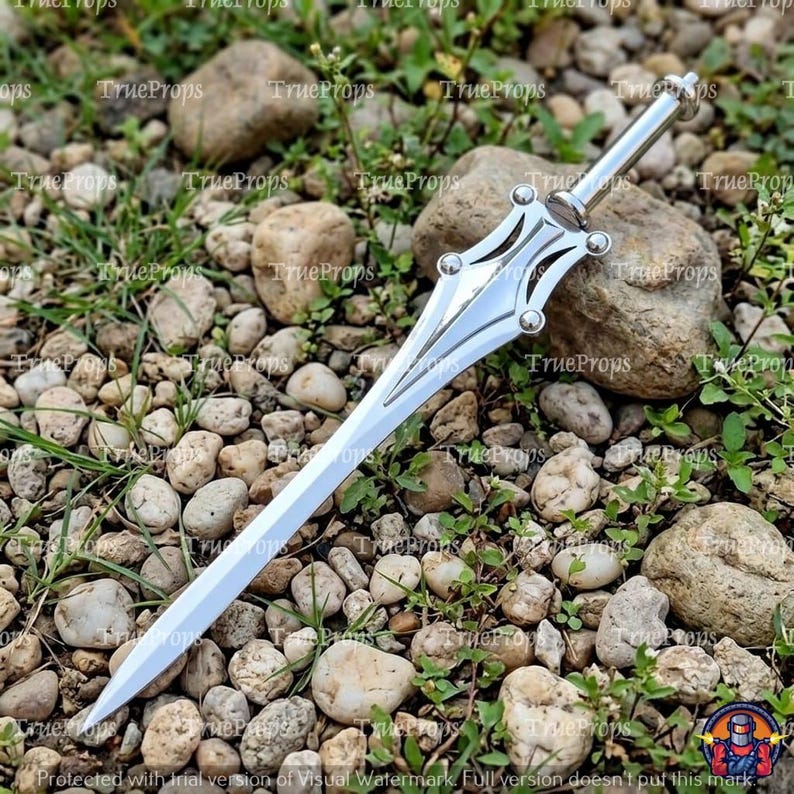May include: A silver-colored metal dagger featuring a pointed blade and a decorative hilt with four rounded studs. The handle is cylindrical and smooth, leading to a symmetrical guard that tapers into a sharp, straight blade with a polished finish.