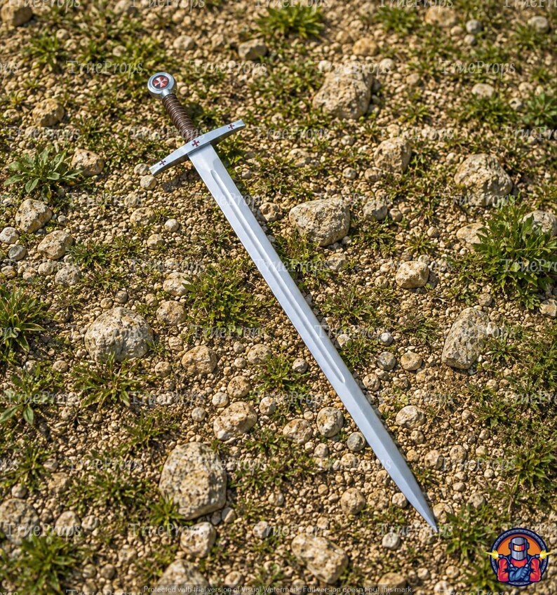 May include: A silver-toned metal sword featuring a long, double-edged blade with a central fuller. The crossguard and pommel are adorned with small red cross emblems. The handle is wrapped in dark brown cord, providing a textured grip.