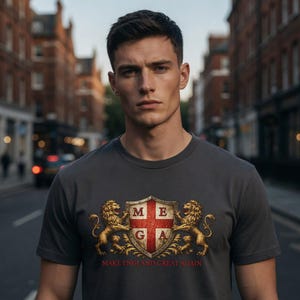 May include: A dark grey t-shirt with a shield design, the letters MEGA, and the slogan "MAKE ENGLAND GREAT AGAIN." Two golden lions flank the shield. The shirt is worn by a person in a city street setting.