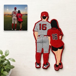 May include: An embroidered patch depicting two figures standing side-by-side. The left figure wears a gray baseball jersey and pants with the number 16 in red, and red socks. The right figure wears a red jersey with the number 16 in black and black shorts.