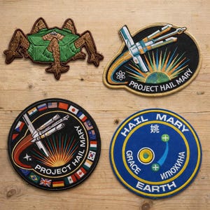 May include: A white ceramic mug with a black handle and the text "But First, Coffee" in a bold, black font. The mug is set against a blurred background, suggesting a cozy setting.