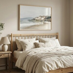 Puede incluir: Un dormitorio con una cama de madera con ropa de cama y almohadas beige. Una pintura de paisaje enmarcada cuelga sobre la cama. Una peque&ntilde;a mesita de noche de madera sostiene una l&aacute;mpara y una planta en maceta, creando un ambiente sereno.