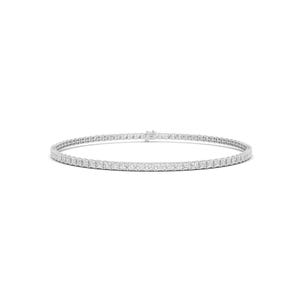 Puede incluir: Una delicada pulsera plateada con una línea continua de piedras preciosas cuadradas y brillantes. La pulsera se presenta sobre un fondo blanco liso, resaltando el diseño intrincado y el brillo de las piedras. El cierre es visible. Aproximadamente 17 cm de largo.