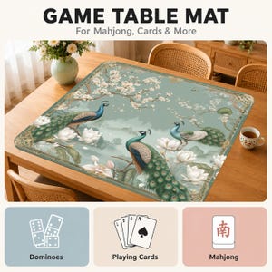 May include: A rectangular game table mat featuring a sage green background with two peacocks, white lotus flowers, and cherry blossom branches. The mat includes text reading GAME TABLE MAT For Mahjong, Cards & More, plus icons for dominoes, cards, and mahjong.