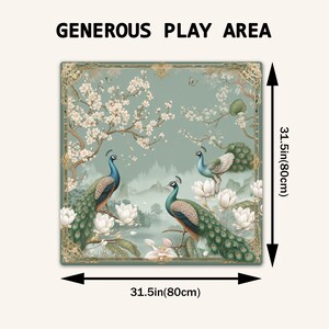 May include: A square play mat featuring a green background with three peacocks, white lotus flowers, and cherry blossom branches. The text "GENEROUS PLAY AREA" is at the top. Arrows indicate dimensions of 31.5 inches by 31.5 inches.