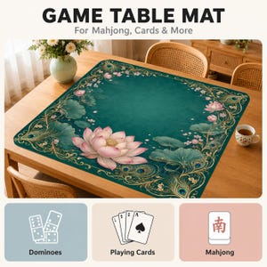 Op de afbeelding: Een vierkante speeltafelmat met een diepblauwe achtergrond, een grote roze lotusbloem, groene waterleliebladeren en gouden pauwenveeraccenten. De tekst luidt GAME TABLE MAT For Mahjong, Cards & More, met iconen voor dominostenen, speelkaarten en mahjong.