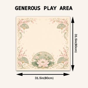 Puede incluir: Una alfombra de juego cuadrada con el texto GENEROUS PLAY AREA y un dise&ntilde;o floral de flores de cerezo rosas, abanicos plegables verdes y una flor de loto central. La alfombra mide 80 cm por 80 cm, seg&uacute;n indican las flechas de dimensi&oacute;n.
