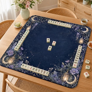 Può includere: Un tappetino da mahjong rettangolare con sfondo blu scuro e motivi celestiali, tra cui lune crescenti, lanterne luminose, fiori viola e cristalli. Il tappetino è disposto con file di tessere bianche da mahjong lungo i bordi.