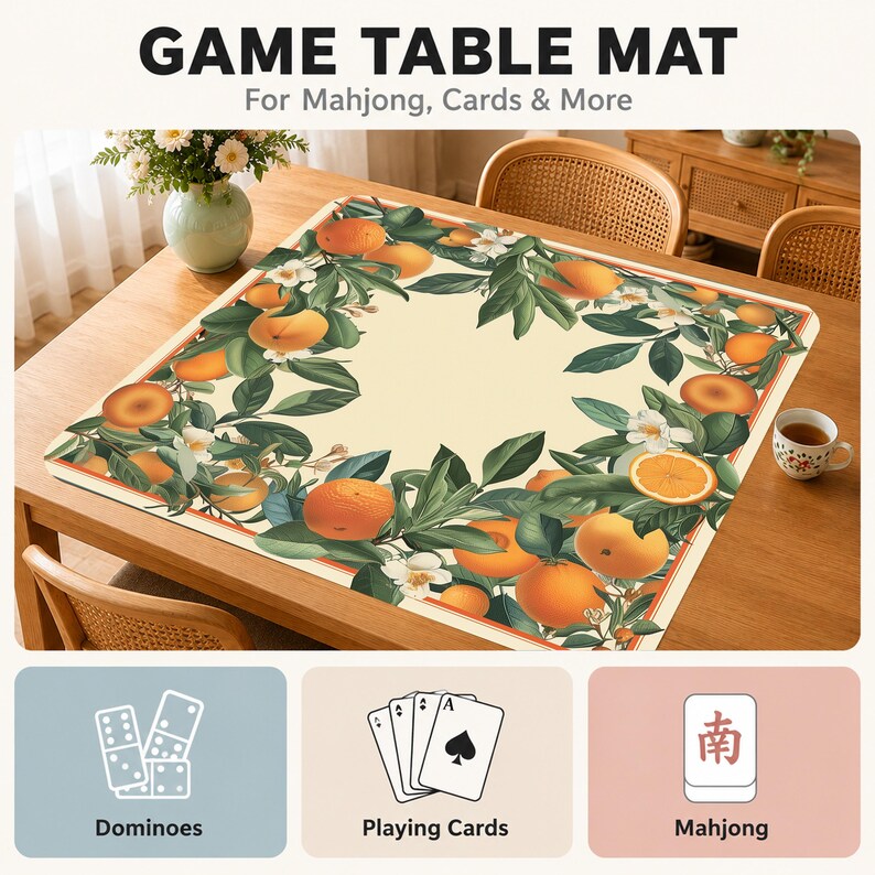Może przedstawiać: Kwadratowa mata do gier z kremowym środkiem i obramowaniem ozdobionym pomarańczami, zielonymi liśćmi i białymi kwiatami. Tekst brzmi GAME TABLE MAT For Mahjong, Cards & More, z ikonami domina, kart do gry i płytek mahjong.