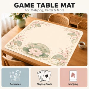 Puede incluir: Un tapete de juego cuadrado con superficie color crema y un borde de flores de loto rosas, hojas verdes y abanicos. El texto GAME TABLE MAT For Mahjong, Cards & More aparece arriba, con iconos de domin&oacute;, cartas y mahjong en la parte inferior.