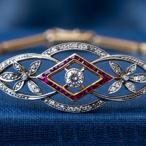 Puede incluir: Una pulsera de oro con un motivo ovalado central con un marco incrustado de diamantes, dos grupos de diamantes en forma de flor y un diamante central engastado en un borde cuadrado de rubíes rojos, flanqueado por dos diamantes redondos.