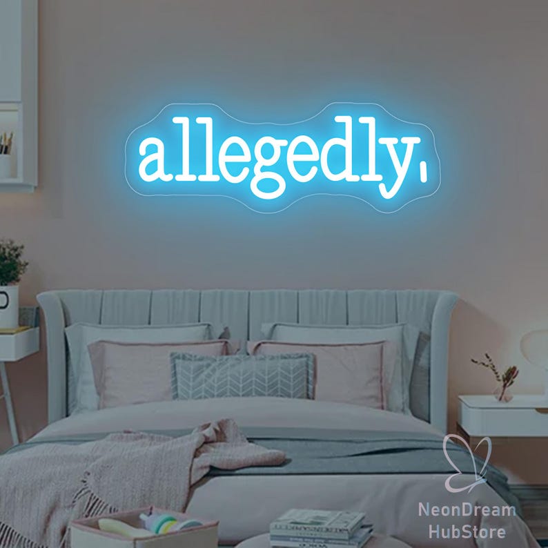 May include: A blue neon sign displaying the word "allegedly," in a cursive font. The sign is mounted on a wall above a bed with pillows and blankets. The room has a soft, pinkish hue.
