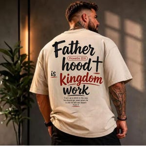 Puede incluir: Una camiseta beige de manga corta con texto en negro y rojo en la espalda que dice Father hood is Kingdom work, Proverbs 22:6, y Train up a child in the way he should go, even when he is old he will not depart from it.