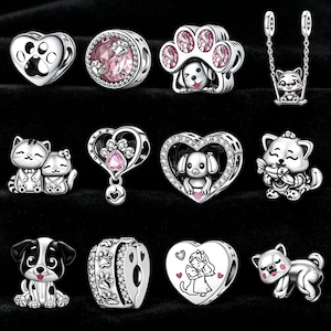 Puede incluir: Colección de abalorios plateados con diseños temáticos de mascotas. Los abalorios incluyen huellas de patas, perros, gatos y corazones, algunos con detalles en rosa. Diseñados para pulseras o collares.
