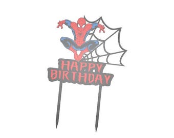 May include: A red, blue, and black Spider-Man cake topper with a web design. The topper has the words "HAPPY BIRTHDAY" in red and gray. The topper is attached to two gray stakes.
