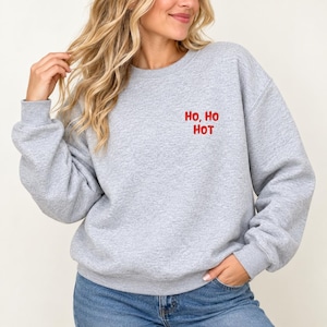Frau trägt graues Sweatshirt mit rotem Brustaufdruck Ho, Ho Hot, lustiger Weihnachtspulli