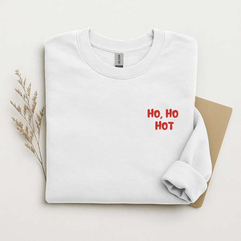 Weißes Sweatshirt flach gelegt mit rotem Brustaufdruck Ho, Ho Hot