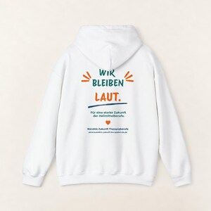 May include: A white hooded sweatshirt featuring back text that reads WIR BLEIBEN LAUT. F&uuml;r eine starke Zukunft der Heilmittelberufe. B&uuml;ndnis Zukunft Therapieberufe, along with a small orange heart icon and the website buendnis-zukunft-therapieberufe.de.