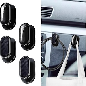 Op de afbeelding: Set van vier zwarte autohaken met een koolstofvezelachtige textuur. De haken worden afzonderlijk en in gebruik getoond, met een kabel en een draagtas. De haken hebben een strak, modern design.