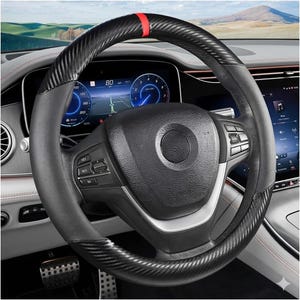 Può includere: Un volante nero e grigio con un design in fibra di carbonio e una striscia rossa. Il volante si trova all'interno di un'auto con un cruscotto digitale che mostra la velocità e la navigazione.