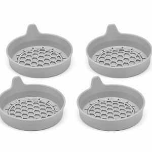 May include: Four light gray silicone coasters with a honeycomb pattern in the center and a small handle. The coasters are round with a slightly raised edge to contain spills. The design is simple and modern.