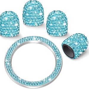 Op de afbeelding: Een set van vijf auto-accessoires, waaronder vier ventieldopjes en een zilveren ring, allemaal versierd met sprankelende lichtblauwe kristallen. De doppen hebben een afgeronde vorm en de ring is cirkelvormig. De accessoires zijn ontworpen om een vleugje glamour aan een voertuig toe te voegen.