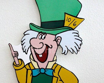 May include: A colorful, cartoon cutout of the Mad Hatter from Alice in Wonderland. The character wears a green top hat, yellow coat, green pants, and a blue bow tie. A yellow tag on the hat reads "10/6".