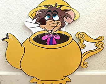 May include: A yellow teapot with a brown mouse peeking out of the spout. The mouse is wearing a pink bow tie and a yellow hat.