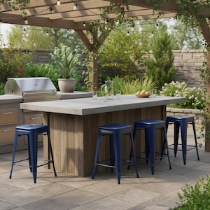 May include: Outdoor kitchen island with a concrete countertop and a wooden base. Four blue metal bar stools are positioned in front of the island. A stainless steel grill is visible in the background, along with a pergola and string lights.