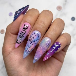 May include: Long, almond-shaped press-on nails with a gradient of pink, purple, and blue. Each nail features unique designs, including a beetle, dragonfly, key, and the word "CORALINE". Some nails are adorned with small, silver embellishments.