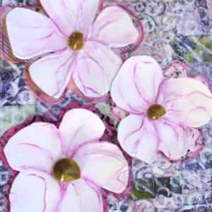 May include: Three handmade paper flowers with white petals, light pink accents, and a gold center. The flowers are set against a patterned background with shades of purple, green, and blue. The flowers have a dark pink border.
