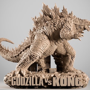 Puede incluir: Escultura detallada de Godzilla en una pose dinámica, con piel texturizada y aletas dorsales. La escultura está sobre una base con el texto "GODZILLA VS KONG". El color es beige neutro.