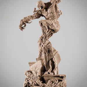 Puede incluir: Estatua detallada de color beige del personaje Carnage de Marvel Comics en una pose dinámica. La figura está sobre una estructura de piedra en ruinas, con la palabra "CARNAGE" en la base. La estatua tiene texturas y detalles intrincados.
