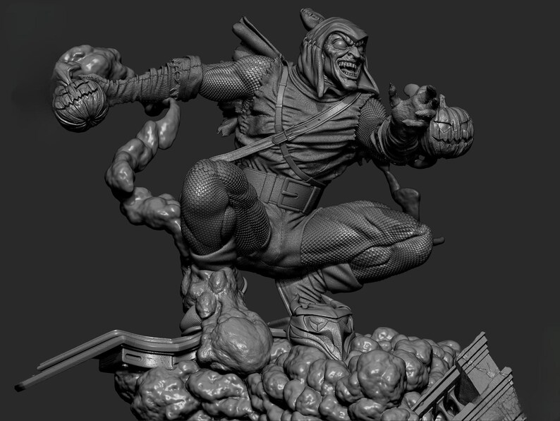 May include: A grayscale sculpture of the Green Goblin, a comic book villain, in a dynamic pose. He is wearing a hooded costume and holding pumpkin bombs. The sculpture is detailed, with textures and a menacing expression.