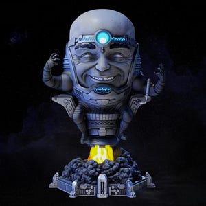 May include: A gray and blue figurine of a character with a large head, seated on a rocket-like base with flames. The character has a smiling face, a glowing blue light on its forehead, and robotic arms.