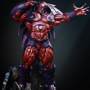 May include: A detailed statue of a muscular figure in a red and purple armored suit. The figure has a helmet with a red face and a purple mask. The statue is posed with one arm raised, showcasing intricate details and textures.