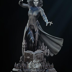 Peut inclure: Statue détaillée d'un personnage en tenue sombre avec une cape flottante, posant avec les mains tendues. La statue est sur une base avec un livre ouvert et des bougies, avec le texte "MULTIVERSE OF MADNESS" à la base.