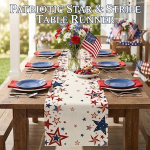 May include: A wooden table set for a patriotic celebration, featuring a cream-colored table runner with red and blue stars. The table is set with blue plates, red napkins, and silverware. A vase of flowers and an American flag complete the festive scene.