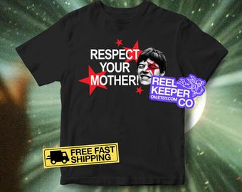 May include: Black t-shirt with the text "RESPECT YOUR MOTHER!" in white and red, along with a graphic of a person's face with a red star. The shirt also has a "FREE FAST SHIPPING" sticker.
