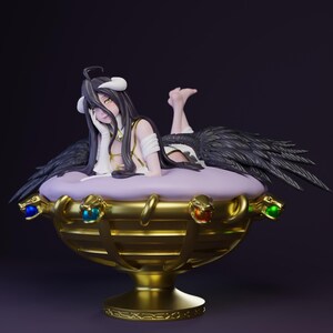 May include: A detailed figurine of a character with black wings, horns, and long hair, reclining on a purple cushion inside a gold-colored decorative bowl. The bowl is adorned with colorful jewels and intricate designs, set against a dark background.