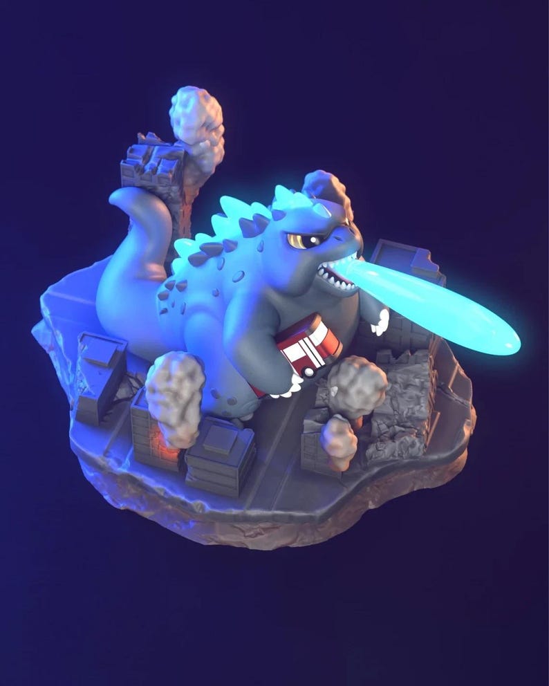 May include: A blue Godzilla figurine with a glowing blue atomic breath, destroying miniature buildings. The figurine is holding a red and white object. The base is a grey island with miniature buildings and smoke.